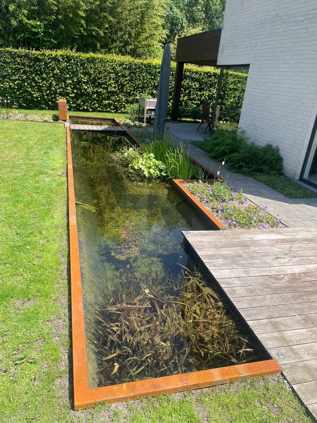 Vijverrand in cortenstaal met hoekafwerking en houten vlonder