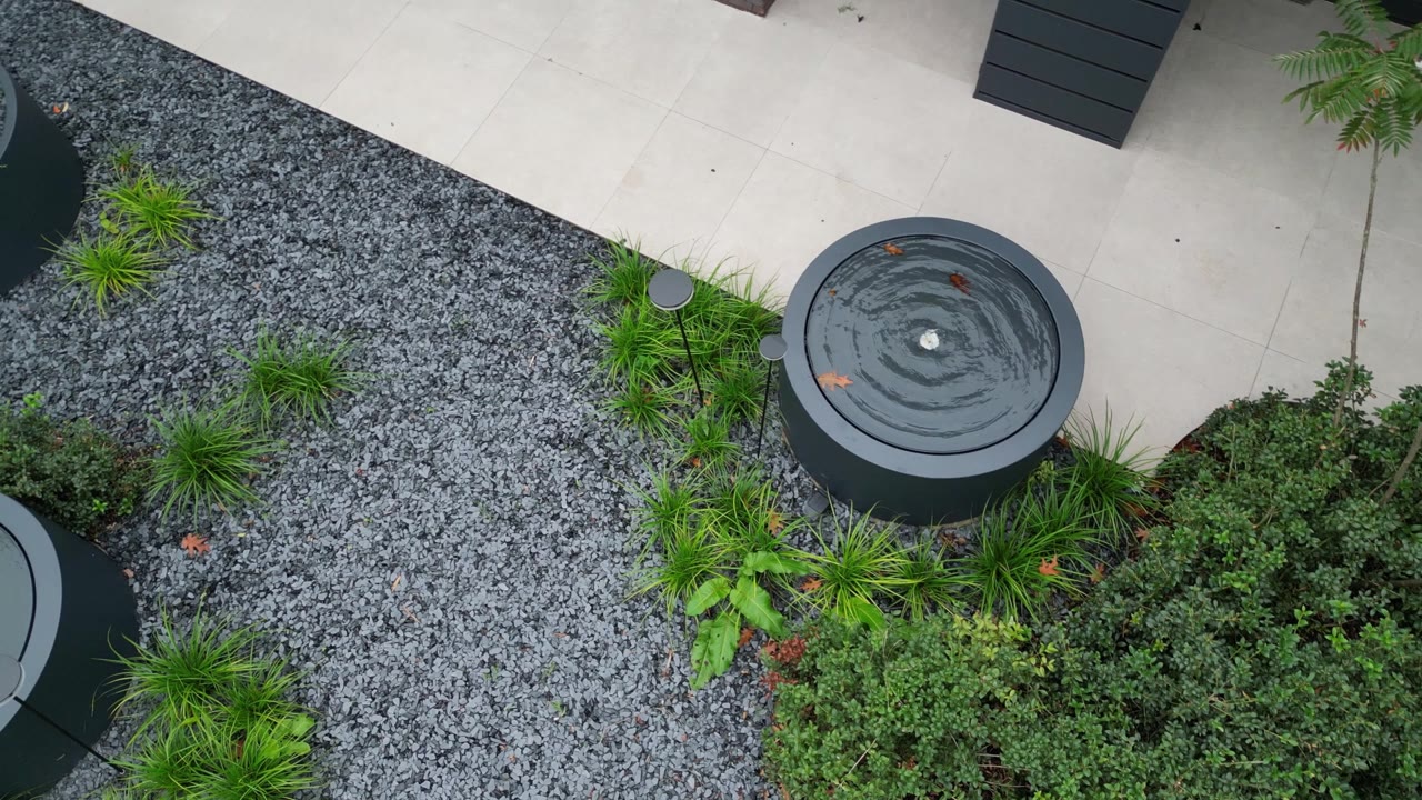 Luchtbeeld van de tuin met drie ronde watertafels van Geroba, ontworpen door Tuinarchitectuur Roeland Vranckx