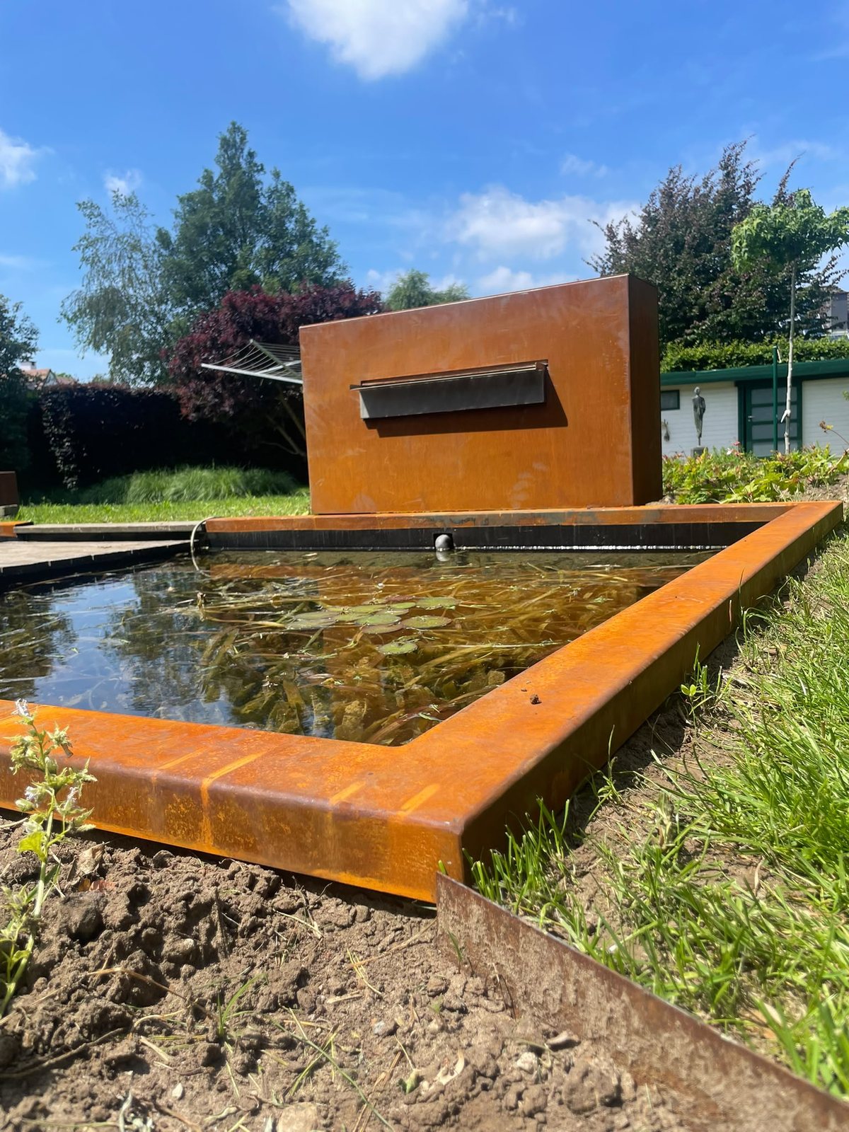 Waterval-afdekking in cortenstaal aan de kop van de vijver
