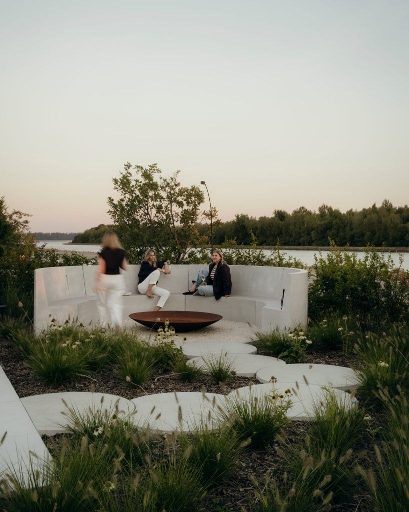 Brasero Diablo en acier corten dans un cercle de banquettes en beton au coucher du soleil, jardin Outspiration d'Ebema